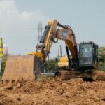 Technician carrying the EG10 hard case away from a SANY excavator