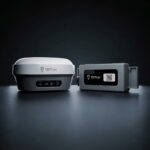 EG10 GNSS receiver and wireless IMU side by side on a dark studio floor